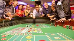 Live Caribbean Stud dealer dealing cards with professional studio lighting and equipment